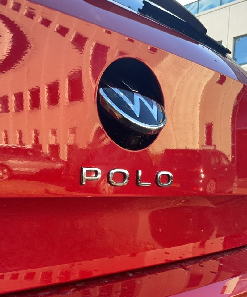 Achterklep van een rode Volkswagen Polo: het VW-embleem staat open en de achteruitrijcamera erachter is zichtbaar